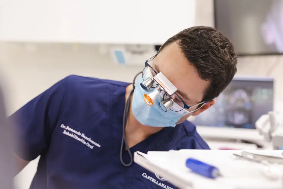 Implantólogo de Castellana Clínica Dental trabajando con lupas de aumento