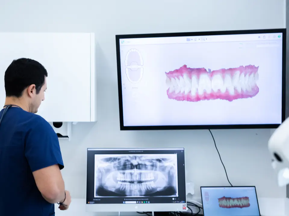 Odontólogo revisando el escaneo y la radiografía 3D de un paciente en pantalla